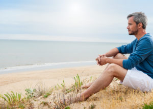 A man relaxes on a beach and looks out at the ocean